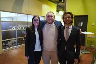 Three members from A Cubed Design at Boost Camp locking arms.