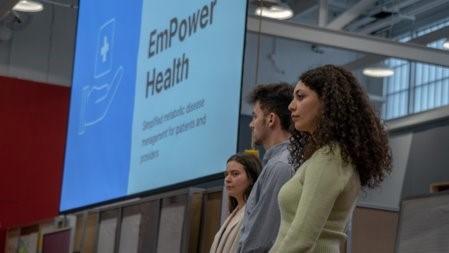Three empower health team members with powerpoint screen