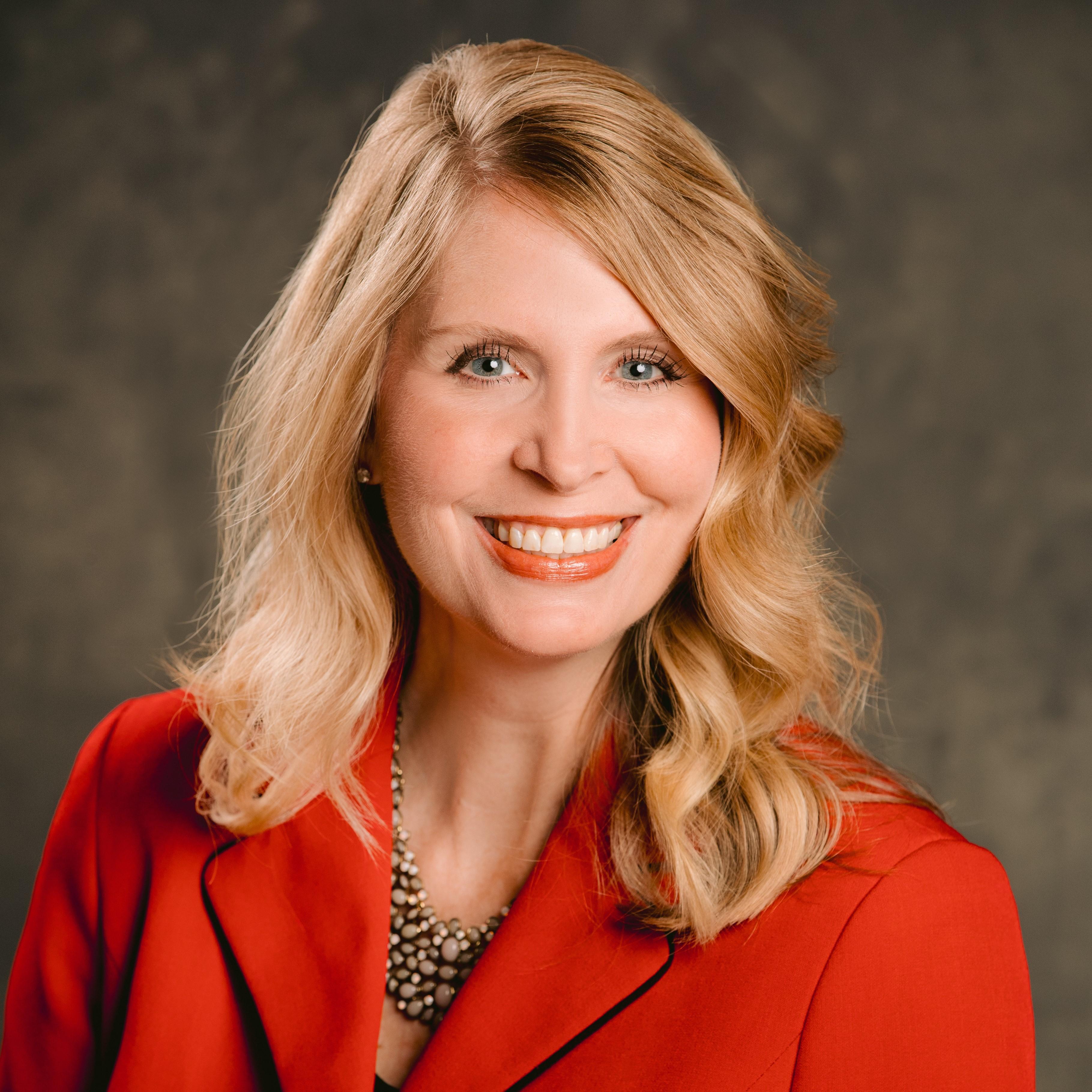 woman with blonde hair and red jacket