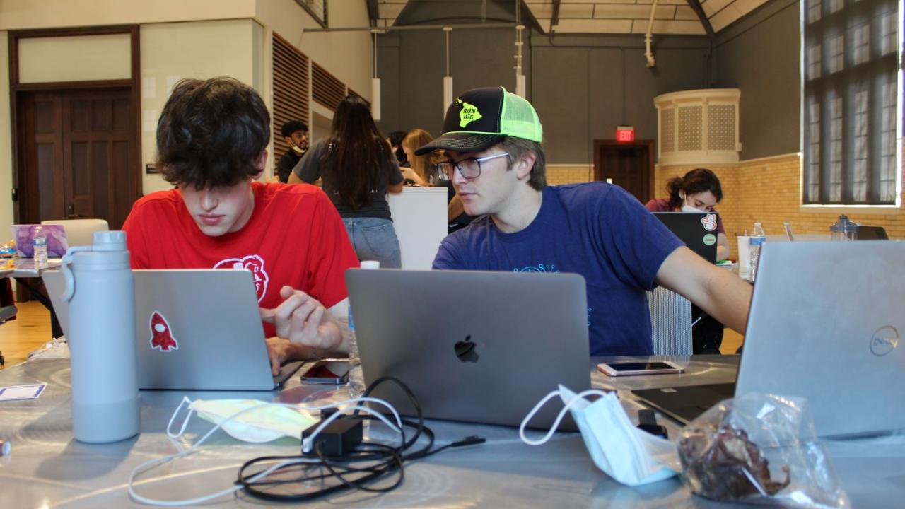 Two male students on laptop computers working on launchpad project
